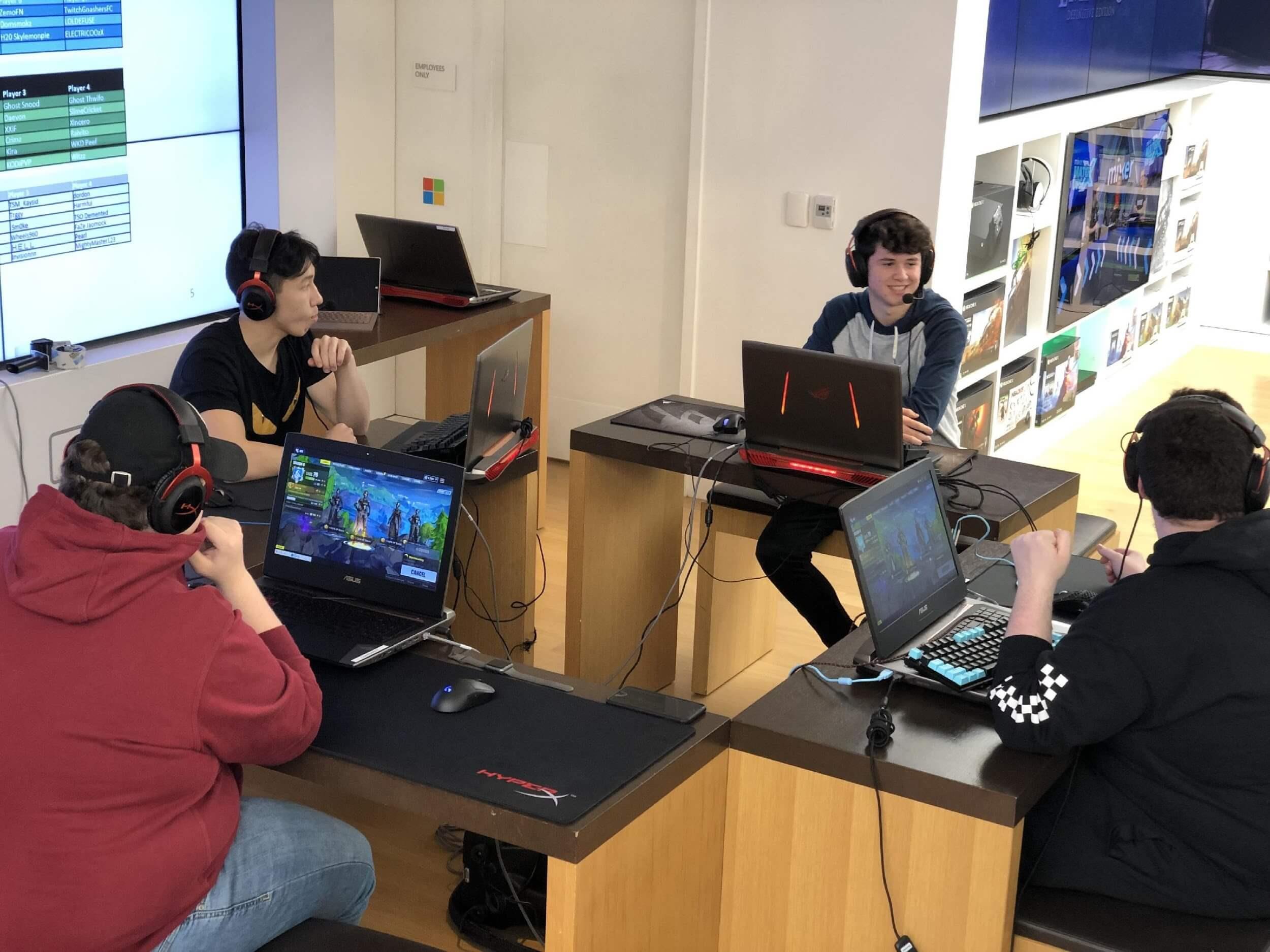 Four gamers playing together on ROG gaming laptops