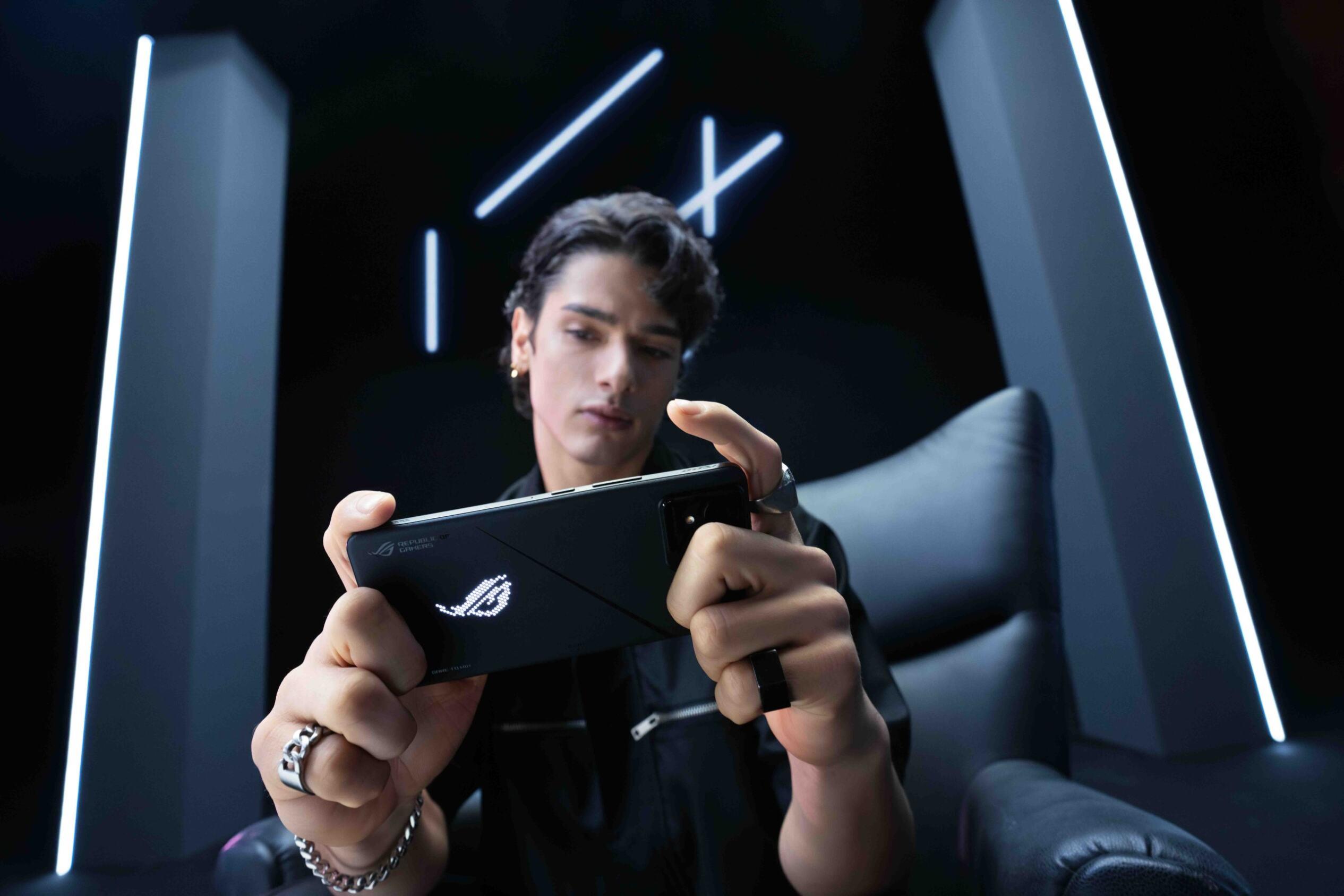A person sitting and holding their ROG phones horizontally